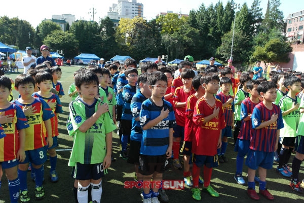 <사진설명> 축구 팀 리그전에 참석한 선수들이 행사에 참가하여 국기에 대한 경례를 하고 있다.