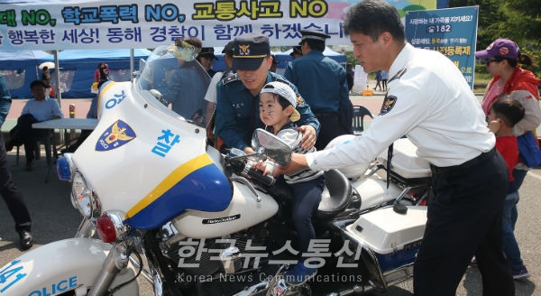 동해시 어린이날 행사에 한 아이가 경찰들과 함께 오토바이체험을 진행하고 있다.