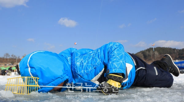 폐막 하루 전날인 3일 2018 인제빙어축제에 참가한 아이가 얼음구멍을 살피며 빙어낚시에 집중하고 있다.