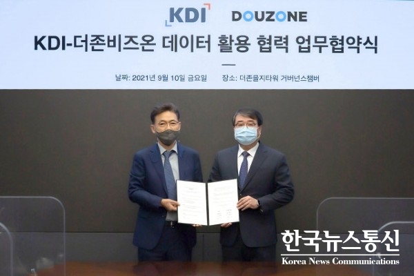 사진 : 왼쪽부터 홍장표 한국개발연구원장과 김용우 더존비즈온 김용우 대표가 업무 협약을 맺고 기념촬영을 하고 있다.