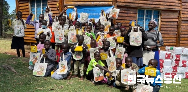 사진 : 케냐 카바넷 어린이들이 후원받은 학용품과 함께 기념 촬영을 하고 있다.