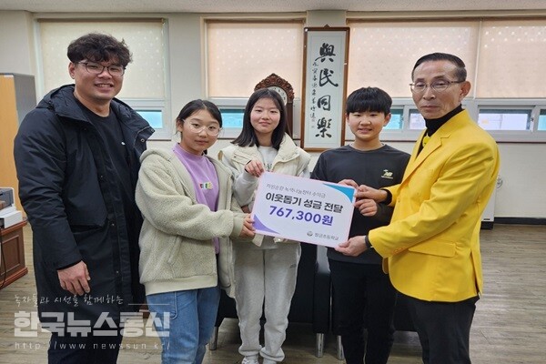 사진 : 5일 팔금 초등학교 학생들과 이창건 선생님이 양현석 팔금면장(오른쪽)에게 불우이웃돕기 성금 전달한 뒤 기념 촬영을 하고 있다.